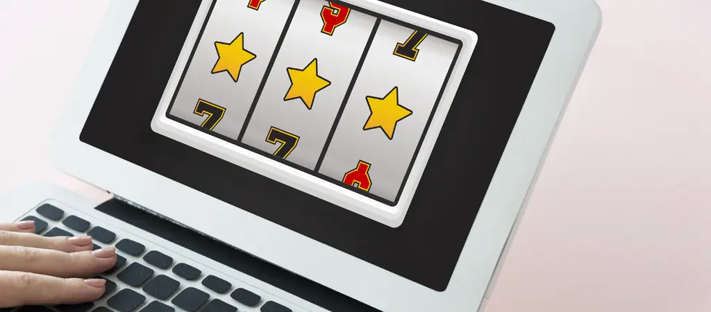 Online szerencsej&aacute;t&eacute;kot &aacute;br&aacute;zol&oacute; laptop kijelző nyerő szimb&oacute;lumokkal &eacute;s digit&aacute;lis kaszin&oacute; grafik&aacute;val