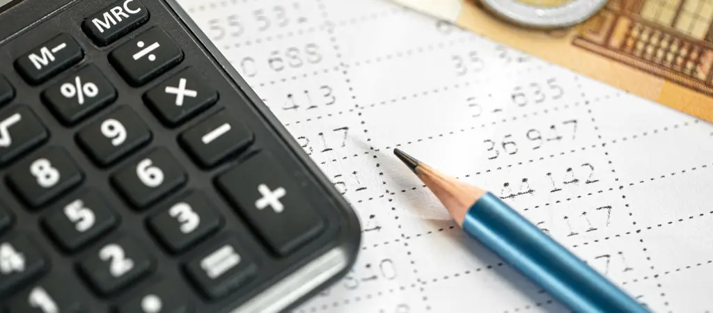 Sz&aacute;mol&oacute;g&eacute;p &eacute;s ceruza egy t&aacute;bl&aacute;zatos pap&iacute;ron, nyerem&eacute;nyad&oacute;val kapcsolatos adatok sz&aacute;m&iacute;t&aacute;s&aacute;ra utal&oacute; k&ouml;rnyezetben