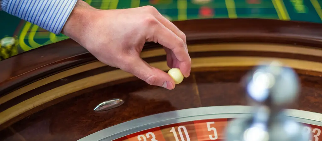 A krupi&eacute; rulettgoly&oacute;t helyez a ker&eacute;kbe, j&oacute;l l&aacute;that&oacute; sz&aacute;msorral &eacute;s klasszikus rulettasztallal