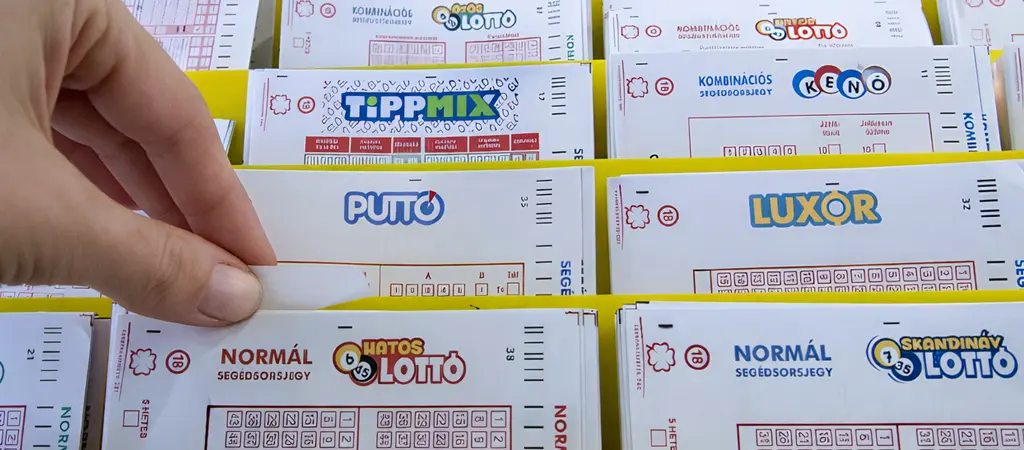 K&eacute;z lott&oacute;szelv&eacute;nyt v&aacute;laszt a k&iacute;n&aacute;latb&oacute;l magyarorsz&aacute;gi lott&oacute;z&oacute;ban Tippmix &eacute;s egy&eacute;b szerencsej&aacute;t&eacute;k szelv&eacute;nyek k&ouml;z&ouml;tt, melyek a lott&oacute;z&oacute; bev&eacute;teli forr&aacute;sai &eacute;s jutal&eacute;krendszer&eacute;nek alapjai