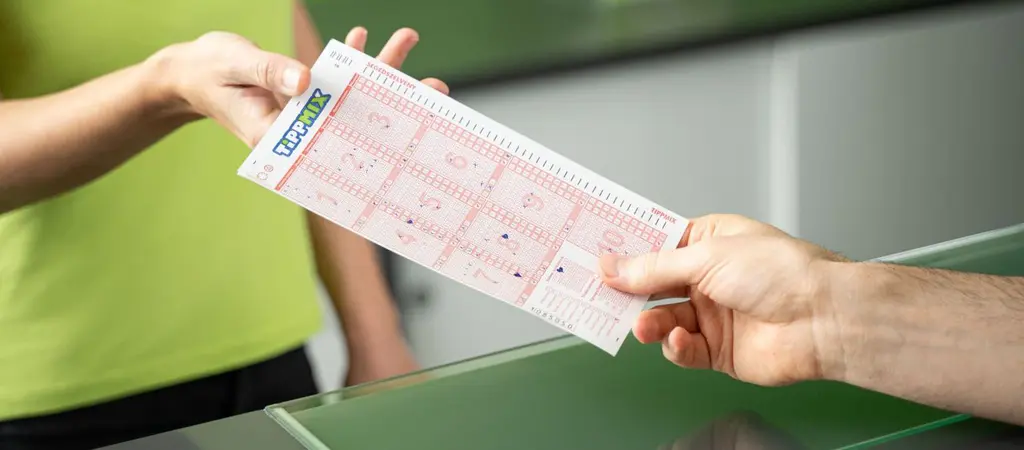 Tippmix szelvény átadása a lottózó pultjánál fogadás leadásakor
