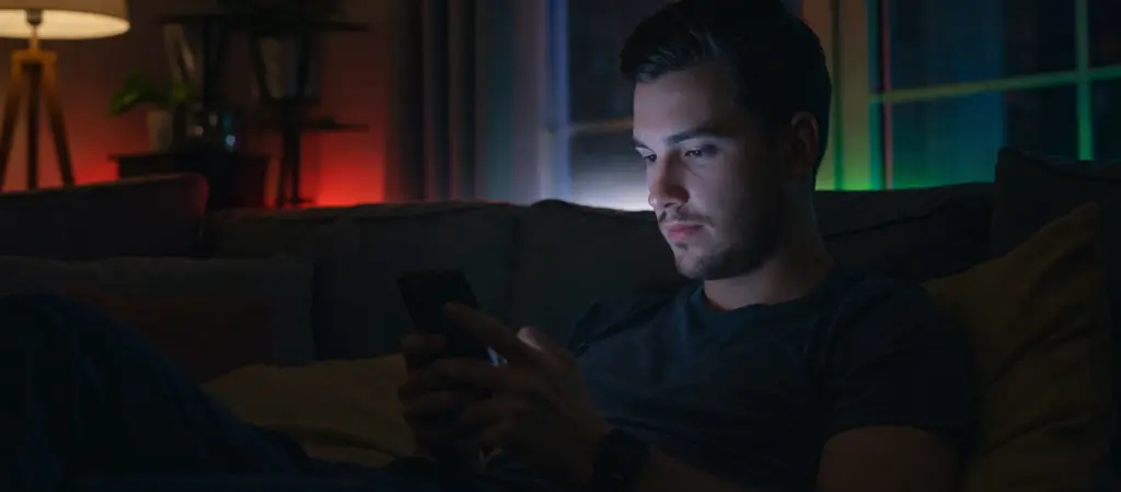 Fiatal f&eacute;rfi mobiltelefonon haszn&aacute;l online kaszin&oacute; alkalmaz&aacute;st otthoni k&ouml;rnyezetben